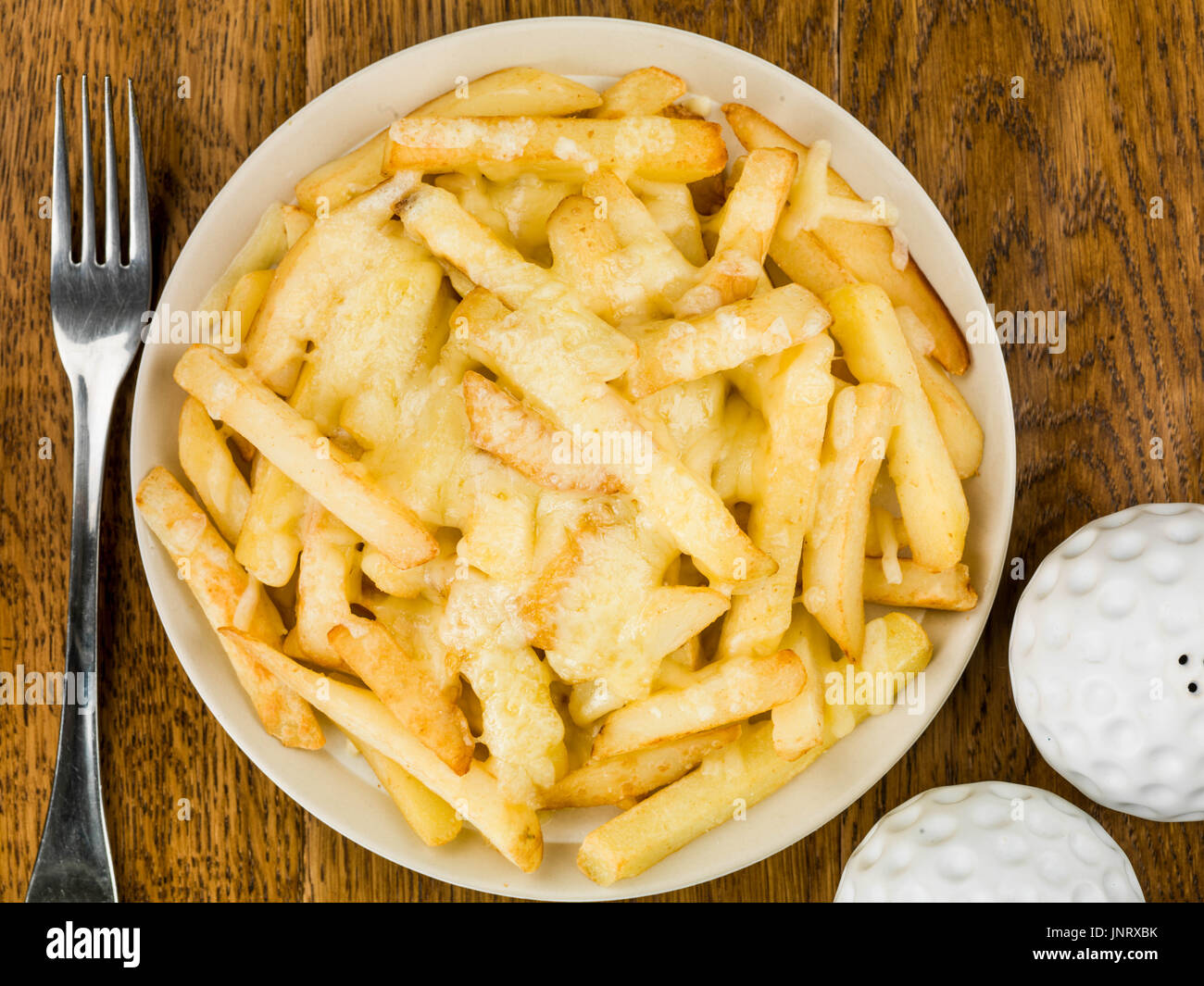 Bowl of Fried and Grilled Cheesy Chips Against a Dark Wooden Oak