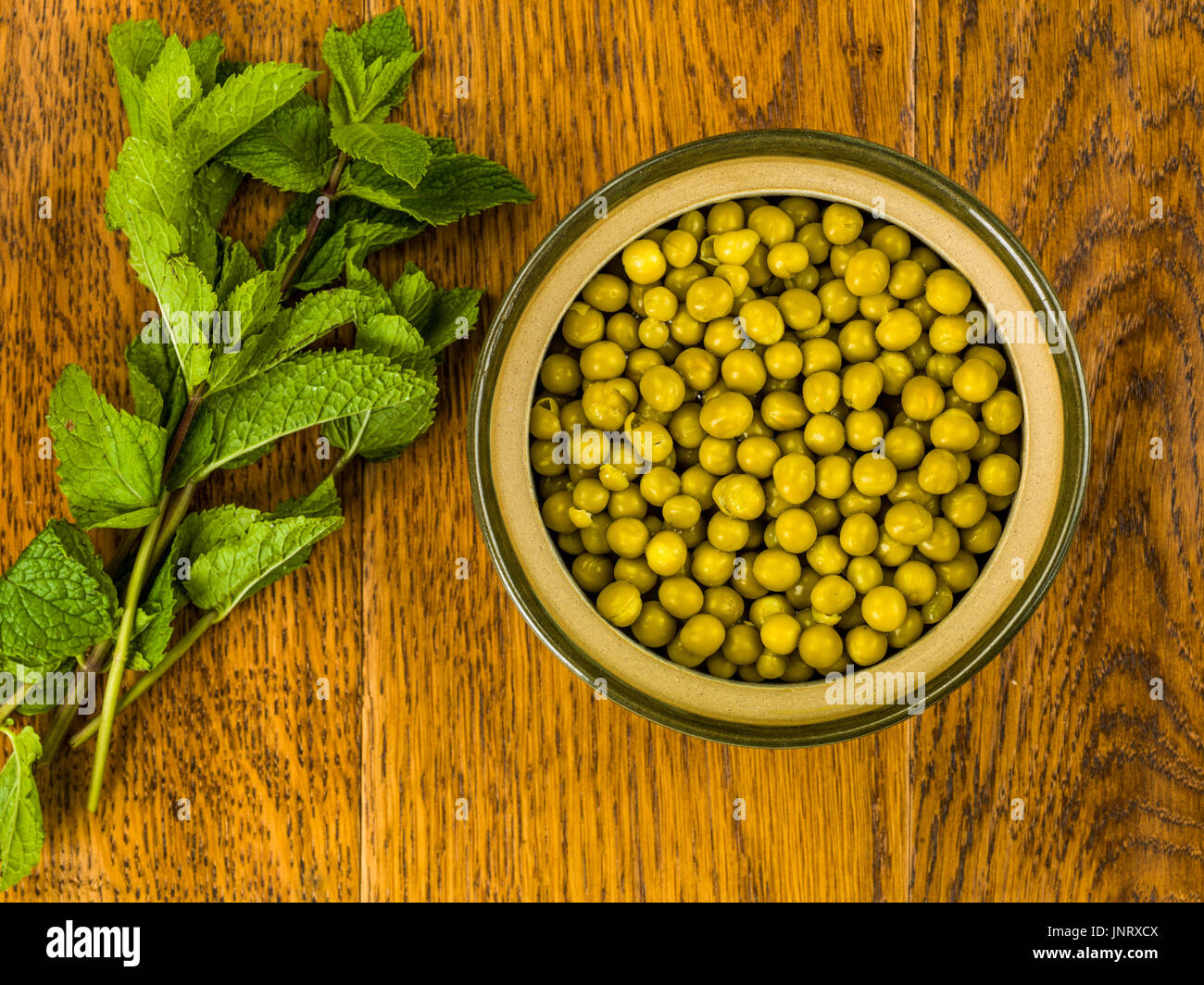 Bowl of Fresh Summer Garden Peas With Fresh Mint Against a Dark Oak Wooden Background Stock Photo