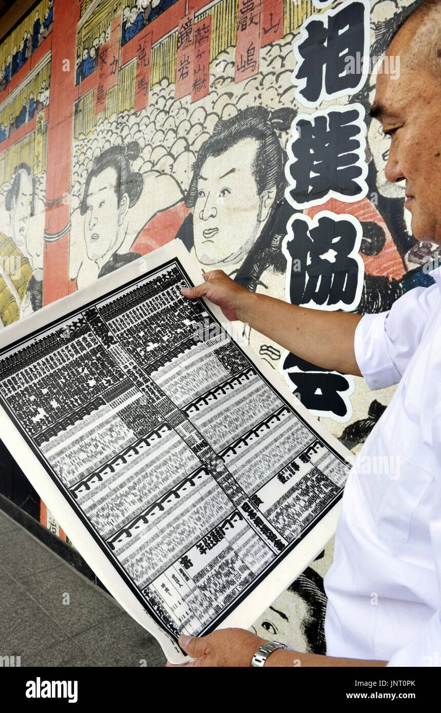 TOKYO, Japan - A sumo fan looks at a new sumo rankings list for the ...