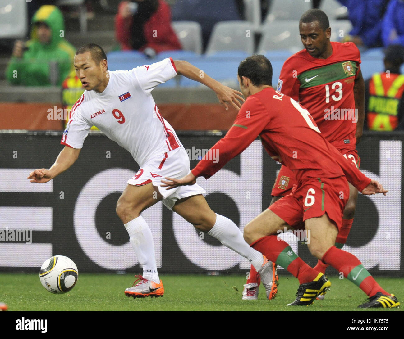CAPE TOWN, South Africa - North Korea striker Jong Tae Se (L) runs past Portugal's Ricardo Carvalho (6) and Miguel (13) during the first half of a World Cup Group G match at Green Point Stadium in Cape Town on June 21, 2010. (Kyodo) Stock Photo