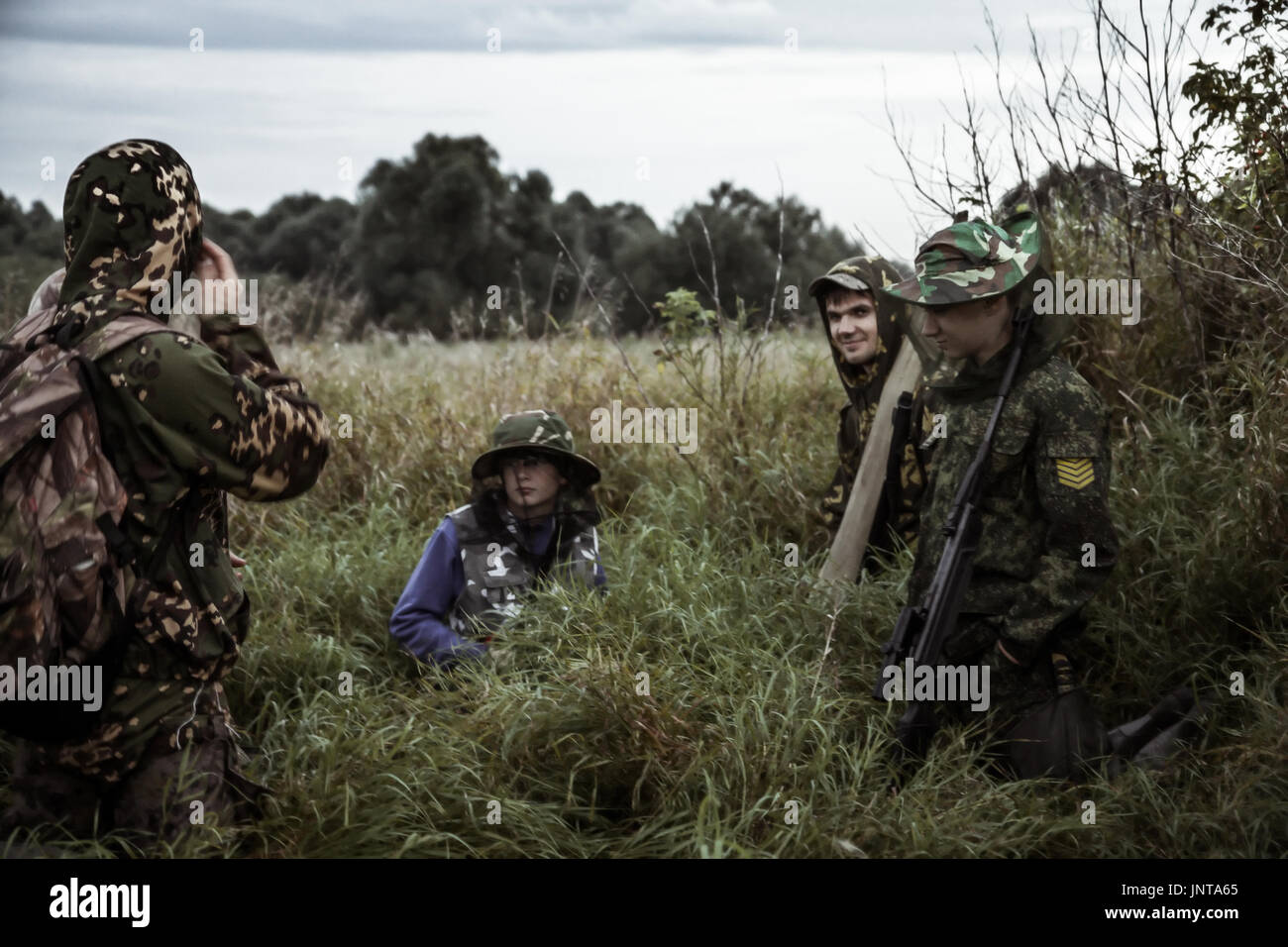 Hunting scene with group of men hunters of different age in rural field