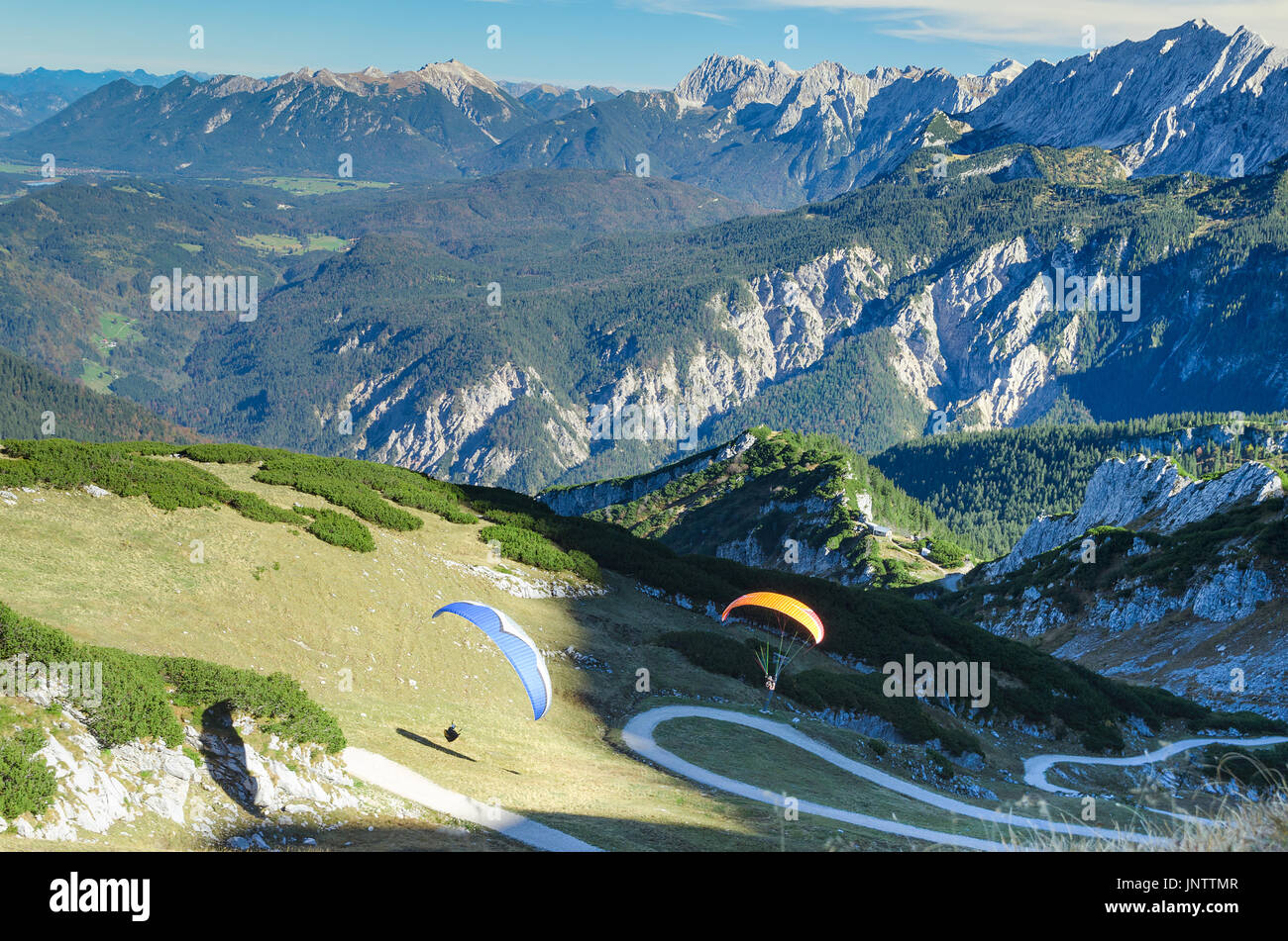Pair paraplanes launching and soaring in Bavarian Alps mountains. Stock photo with aerial view on Alpine landscape. Stock Photo
