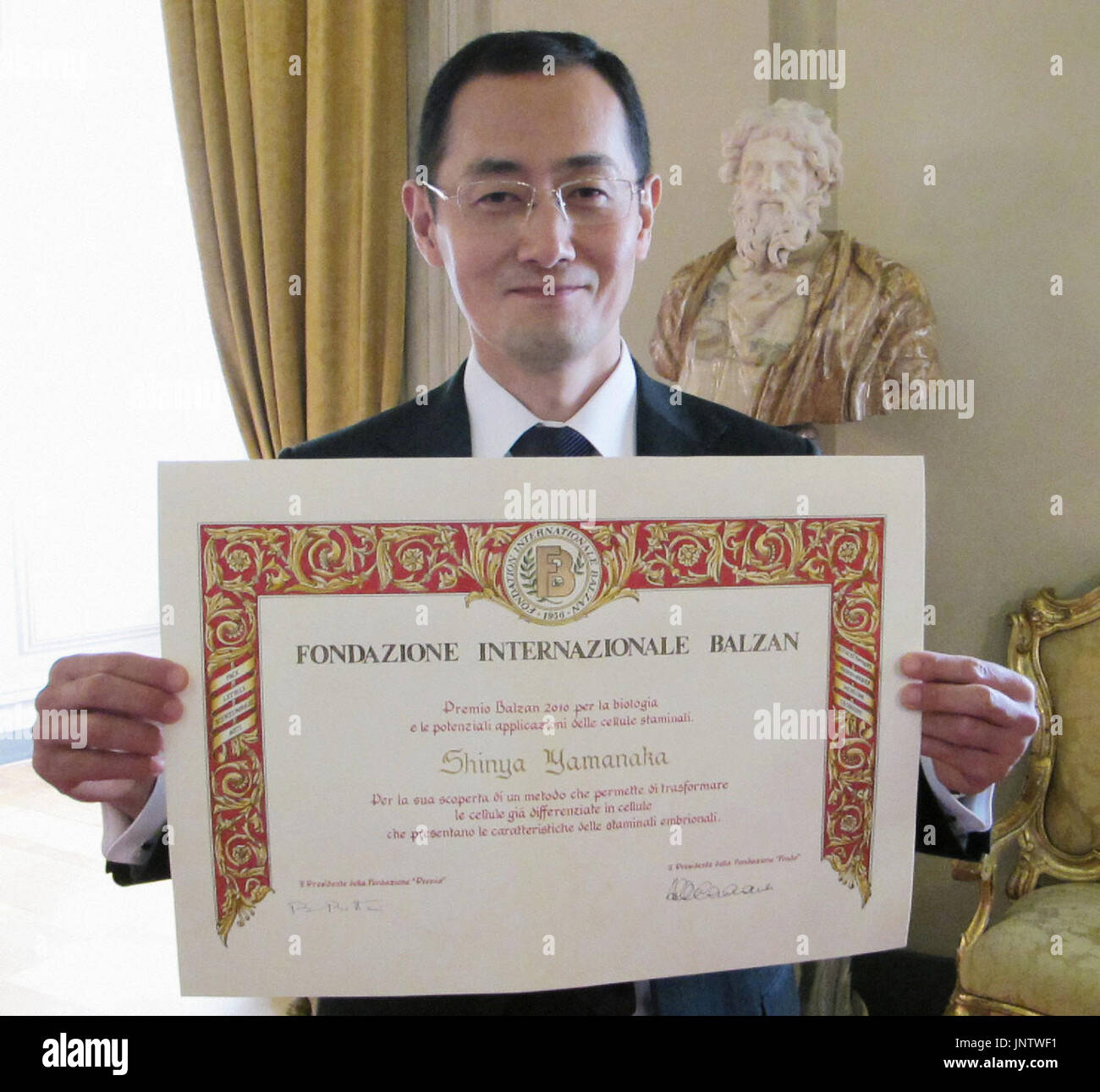 ROME, Italy - Shinya Yamanaka, professor at Kyoto University, holds up a certificate for the Balzan Prize in Rome on Nov. 19, 2010, after winning the award for his pioneering work in producing induced pluripotent stem cells, or iPS cells. (Kyodo) Stock Photo