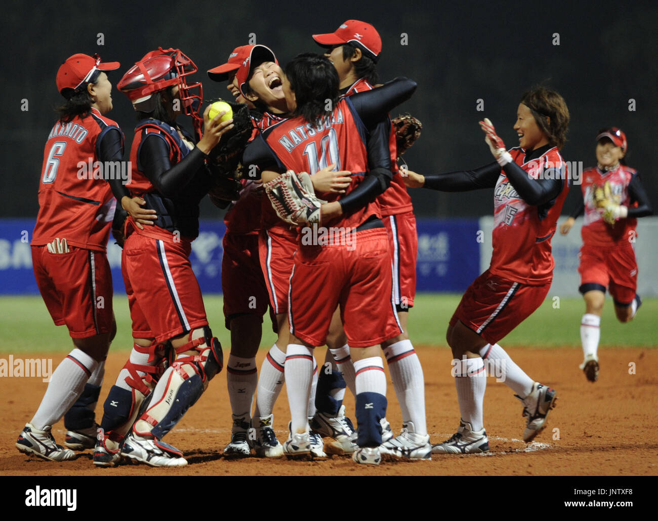 GUANGZHOU, China - Japanese softball players celebrate their 2-0 victory over China on the pitching mound on Nov. 26, 2010, at the Asian Games in Guangzhou, China. Japan won their third consecutive Asian Games softball title. (Kyodo) Stock Photo