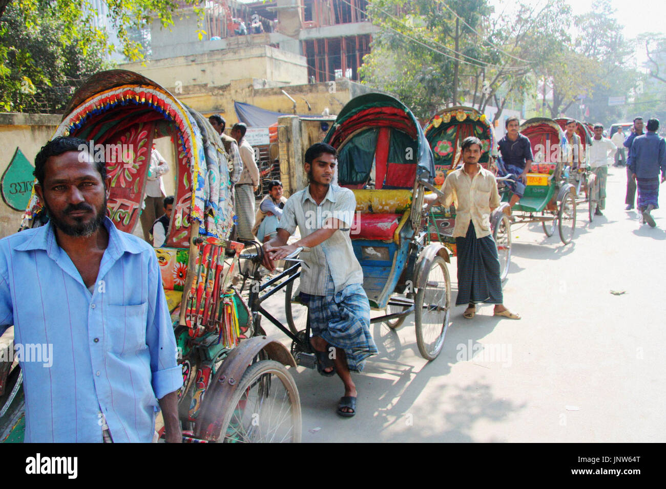 DHAKA, Bangladesh - Drivers of colorful rickshaws wait for customers in ...
