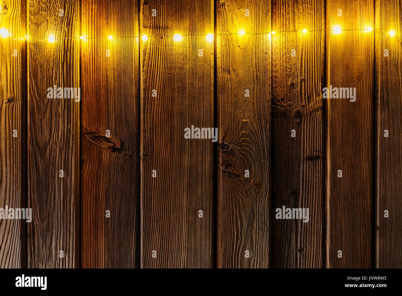 Christmas lights on wooden rustic background. Frame of lights with space for text. Merry Christmas Stock Photo