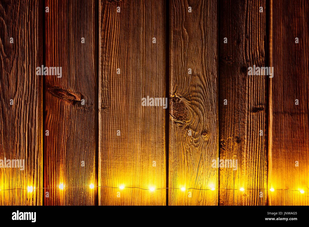 Christmas lights on wooden rustic background. Frame of lights with space for text. Merry Christmas Stock Photo