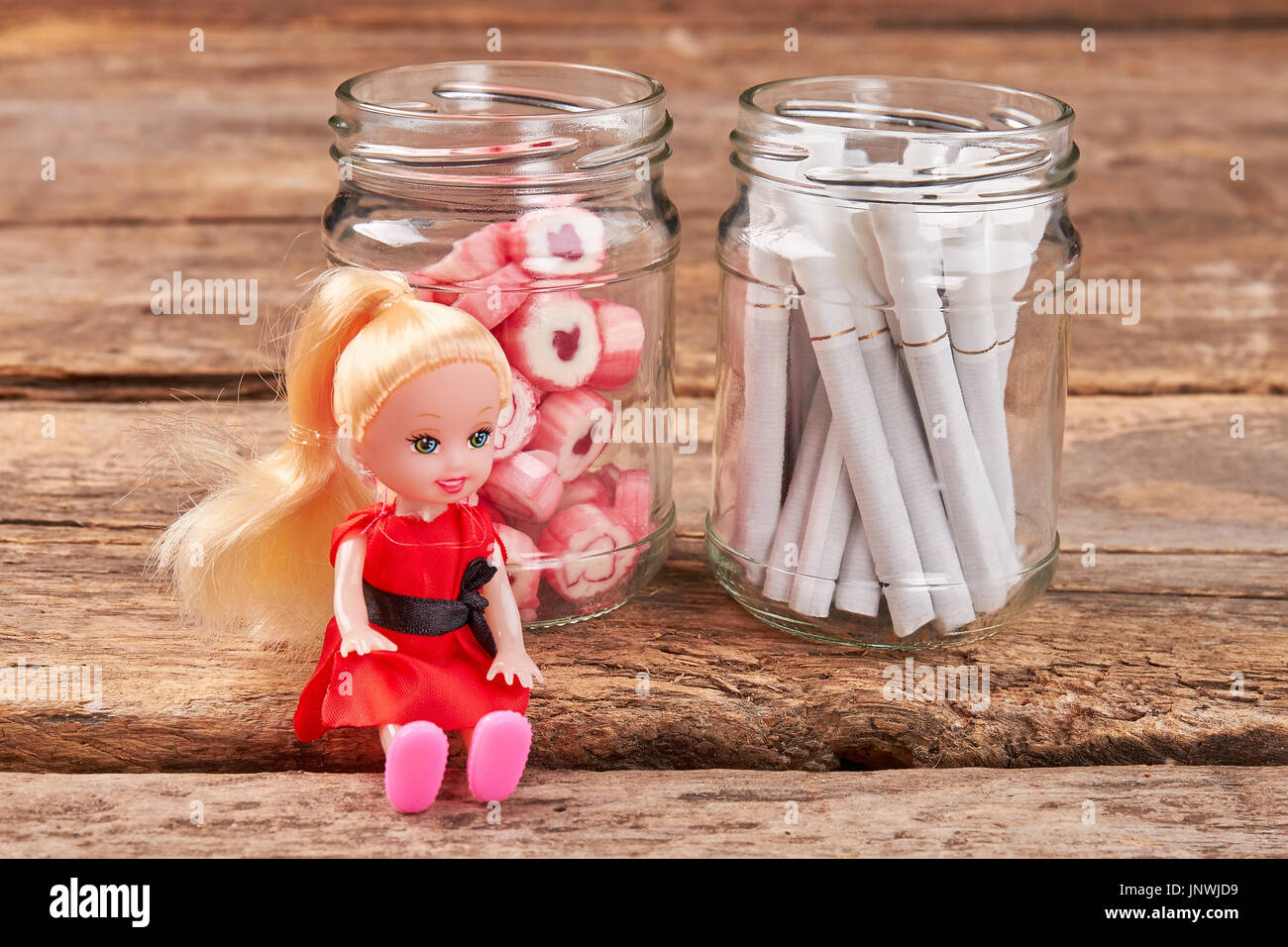 Toy doll sitting near jars. Stock Photo