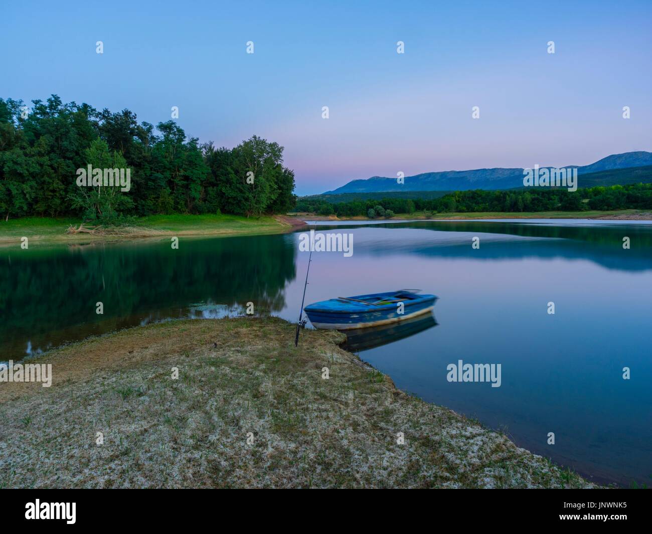 Peruca lake in Croatia fishing stick wooden boat dusk evening time calm calmness Stock Photo