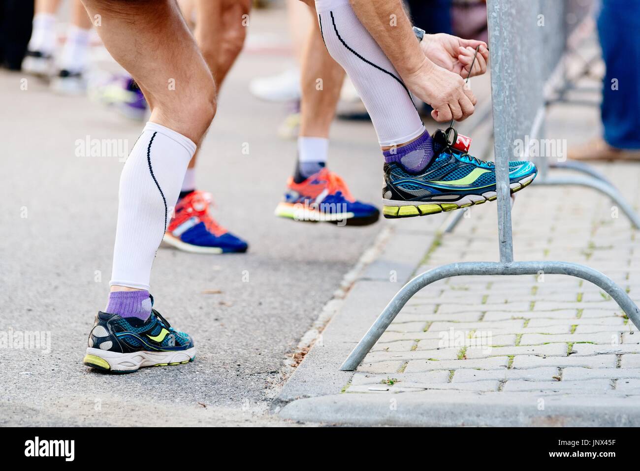 Man ties his sport running shoe before the race. Preparation of sportsman Stock Photo