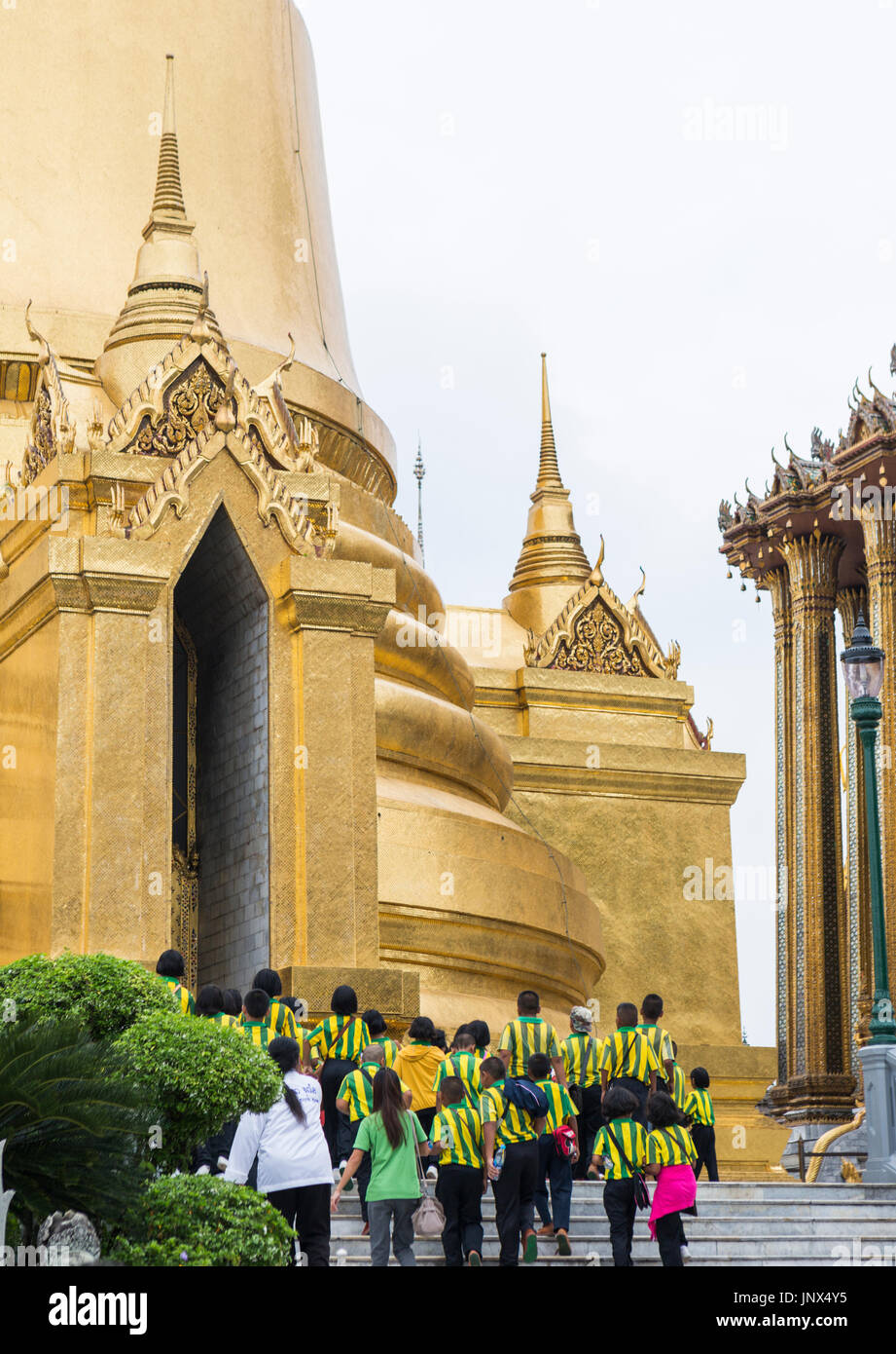 Bangkok, Thailand - February 18, 2015: Group of schoolchildren in yellow and green striped uniform visiting the Grand Palace in Bangkok. Stock Photo