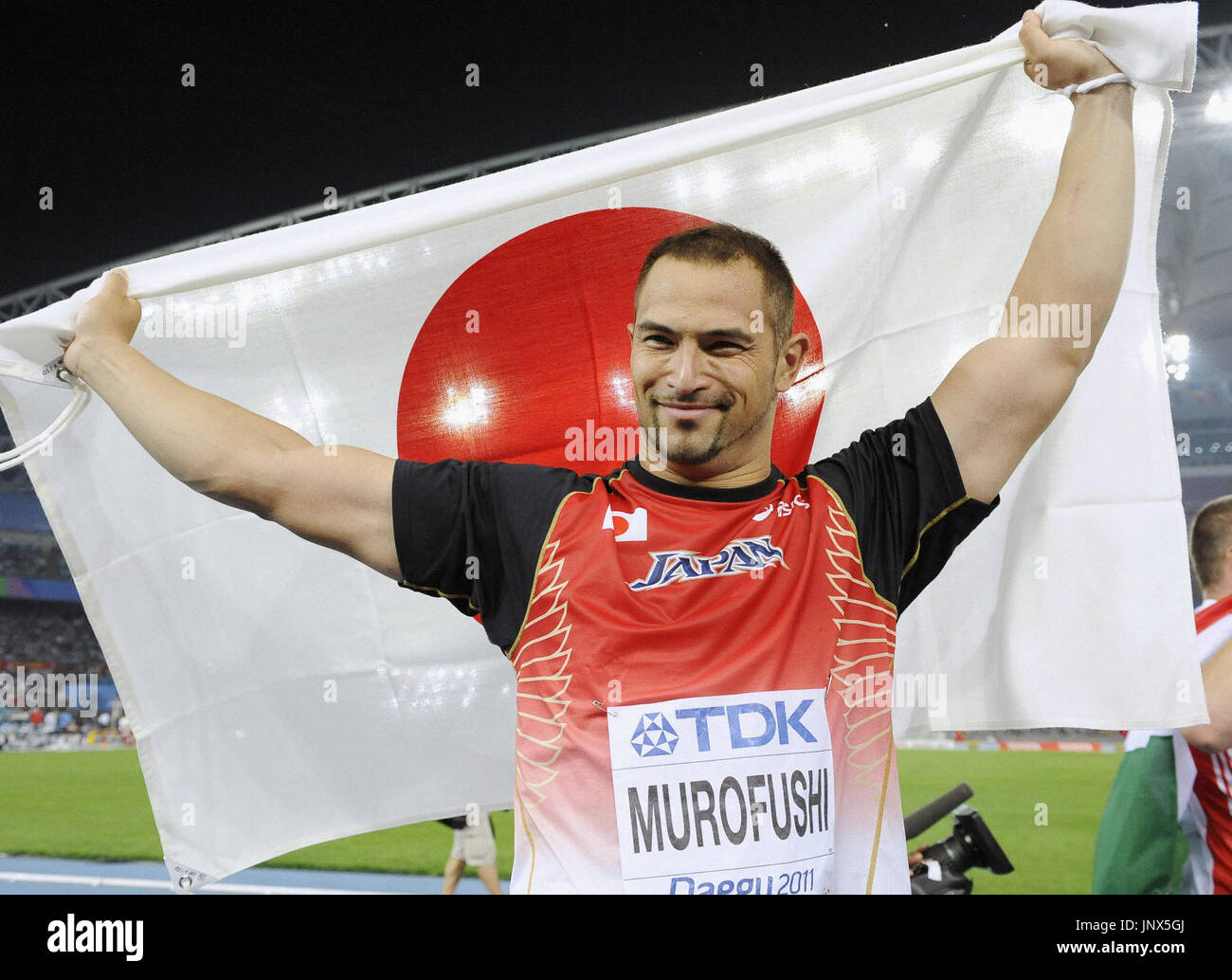 DAEGU, South Korea - Japan's Koji Murofushi, holding up a Japanese national  flag, responds to cheers after winning the gold medal in the men's hammer  throw at the world athletics championships in