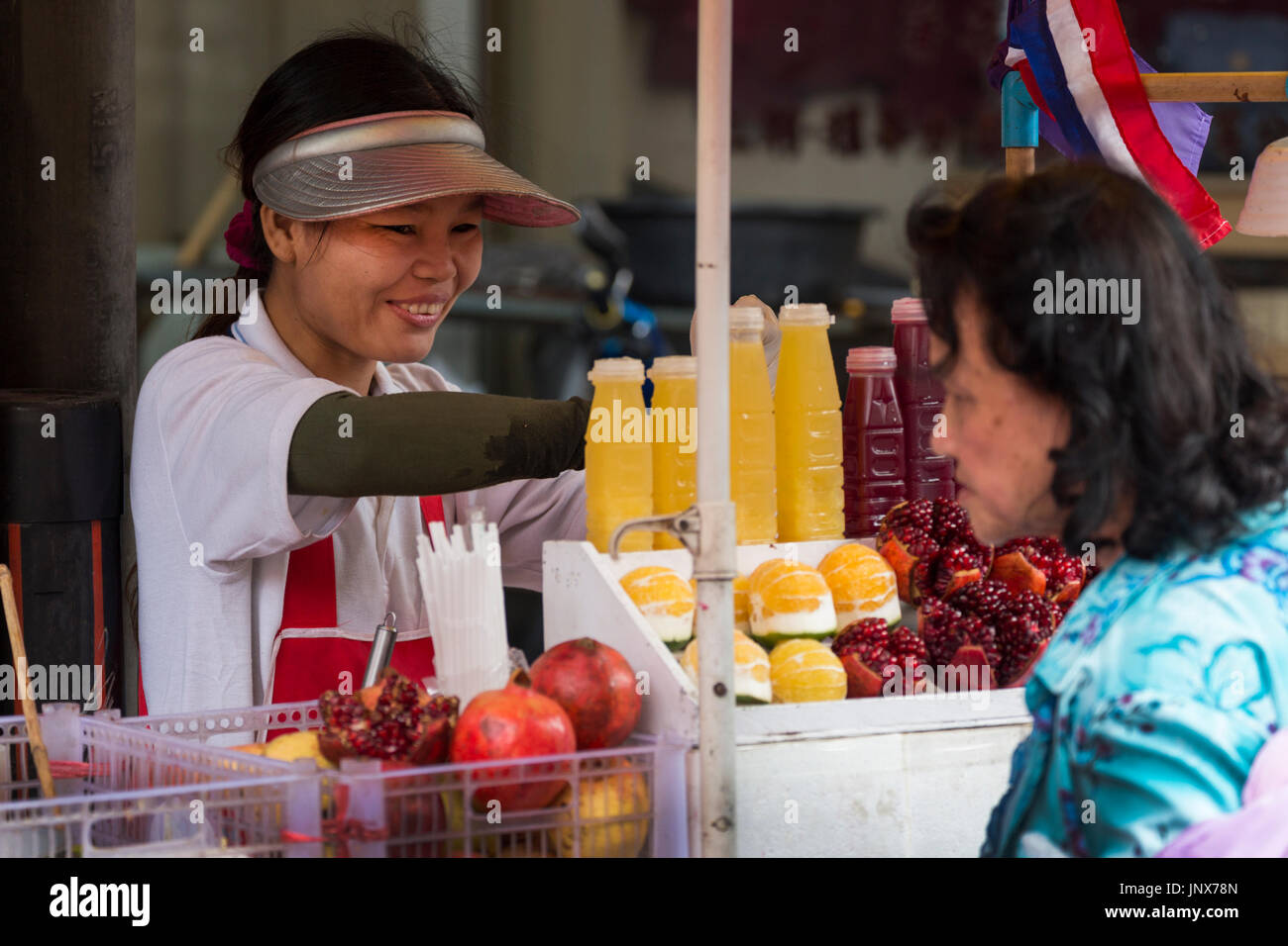 Street vendors selling fruit juice in the street in chinatown hires