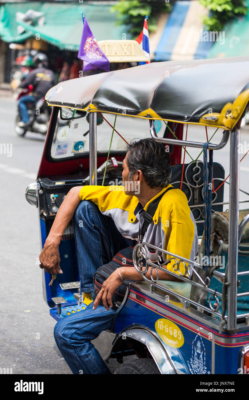 Bangkok, Thailand - February 18, 2015: Tuk-tuk driver in his tuk-tuk waiting for a fare, Bangkok. Stock Photo