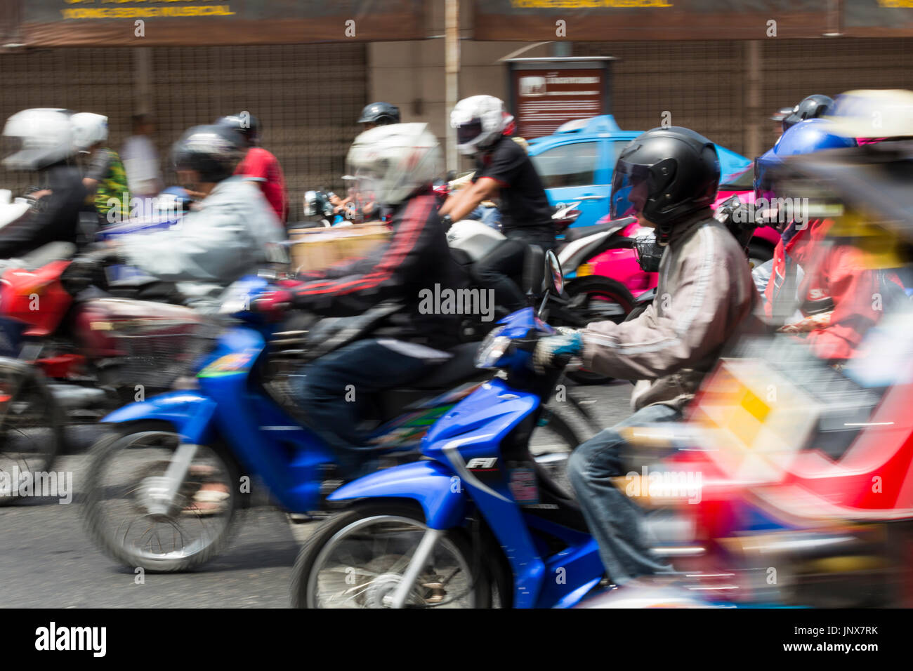Bangkok, Thailand - February 18, 2015: Line of motorcycles moving off from a traffic light in Bangkok. Motorcycles are a very common mode of transport in Bangkok. Stock Photo