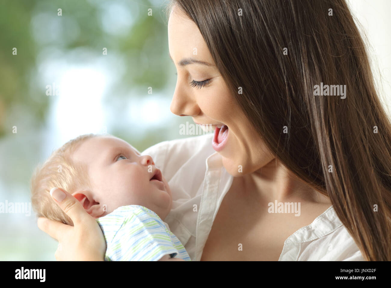 Happy mother holding her baby and playing with him Stock Photo