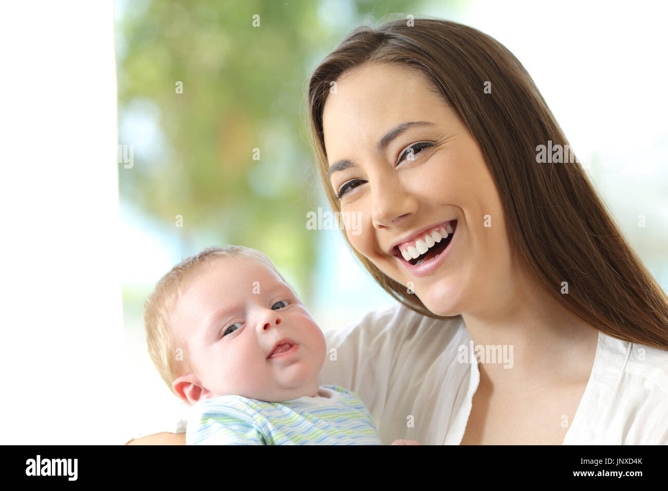 Front view portrait of a happy mother and her baby looking at you Stock Photo