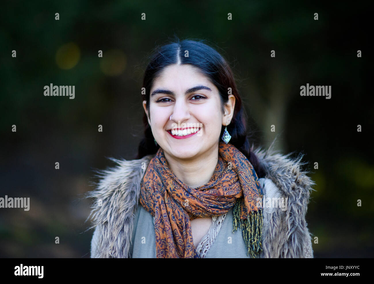 Teenage Persian girl walking in the park on an autumn day Stock Photo