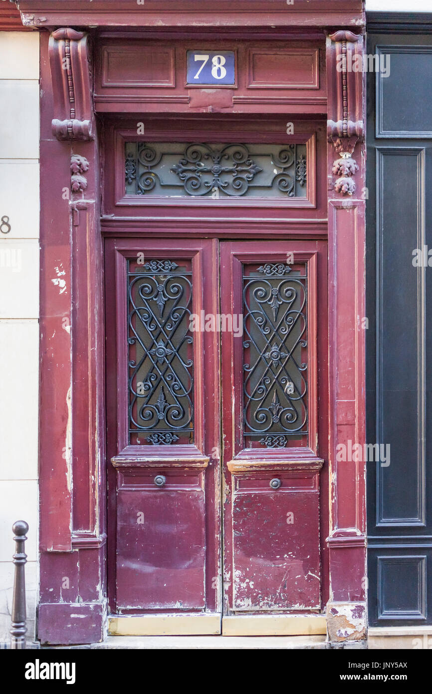 Paris, France - February 29, 2016: Shabby, burgundy colored door in Paris. Stock Photo