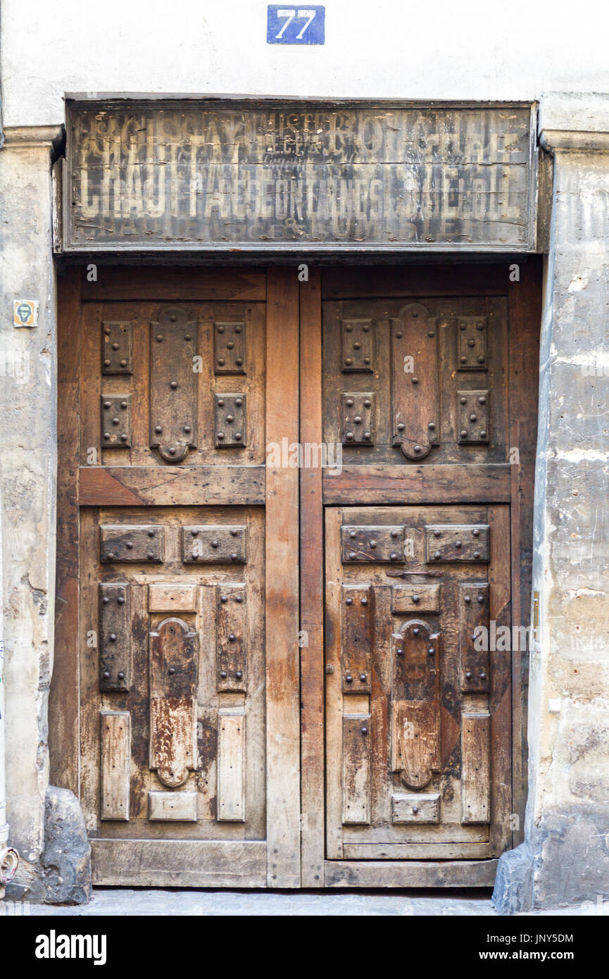 Paris, France - February 29, 2016: Imposing, well-worn brown  door in Paris. Stock Photo