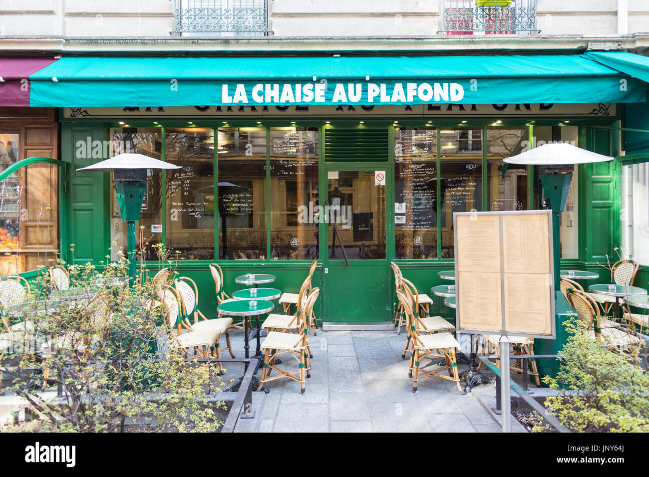 Paris, France - February 29, 2016: Green cafe with tables and chairs in the street in the Marais, Paris. Stock Photo
