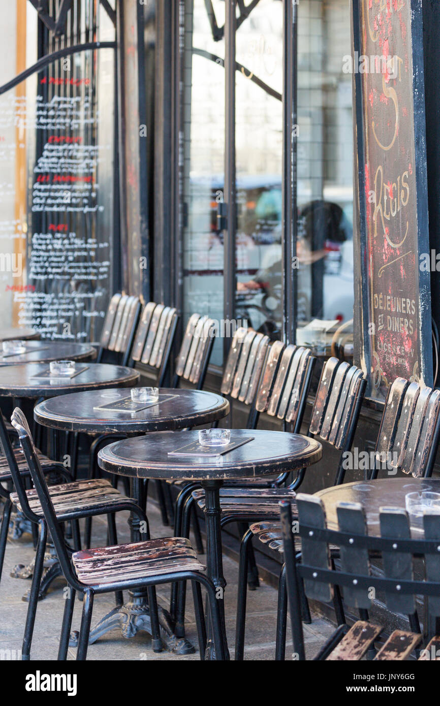 Paris, France - February 29, 2016: Tables and chairs outside the Cafe St-Regis on rue Jean du Bellay, Ile Saint-Louis, Paris. Stock Photo