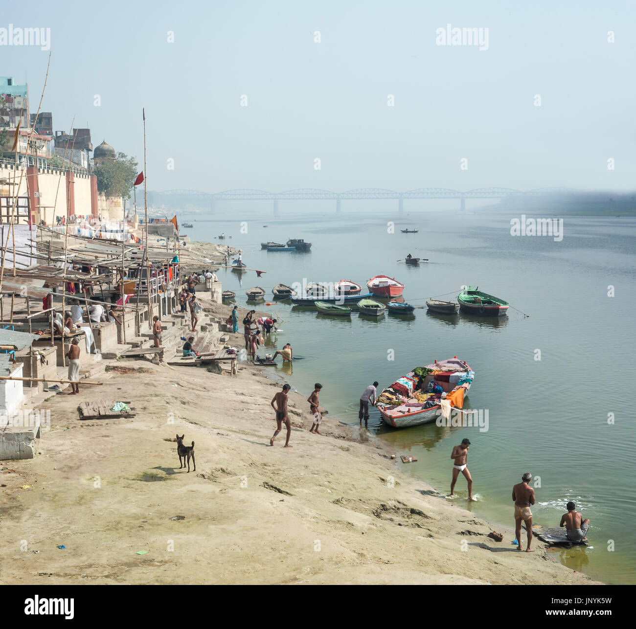 Men wash themselves and laundry on the banks of the Ganges Stock Photo