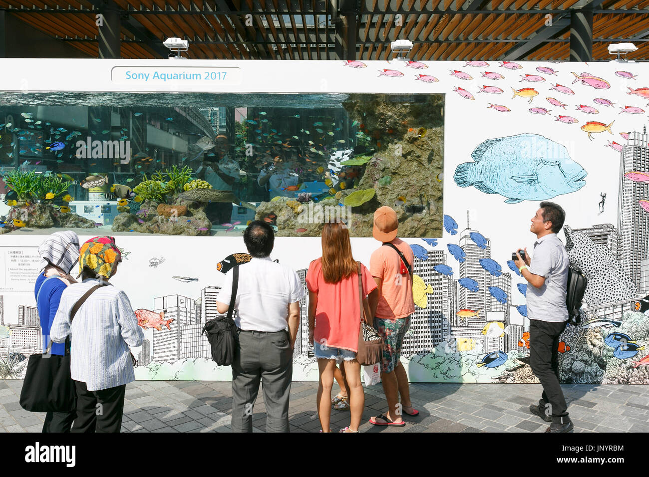 Tokyo, Japan. 31st July, 2017. People look at a huge fish tank with marine animals from Okinawa set up in Yurakucho on July 31, 2017, Tokyo, Japan. ''Sony Aquariums'' are set up in front of Yurakucho station and at Sony Showroom/Sony Store, showcasing different marine animals from the Okinawa Churaumi Aquarium including Napoleon wrasse and Black-spotted moray. Credit: Rodrigo Reyes Marin/AFLO/Alamy Live News Stock Photo