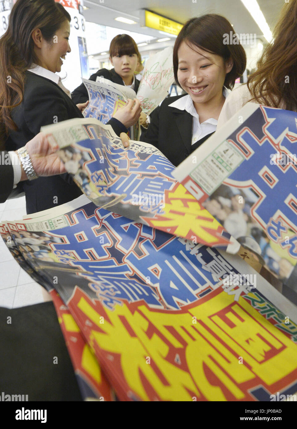 OSAKA, Japan - Women read newspaper extras in front of JR Osaka Station ...