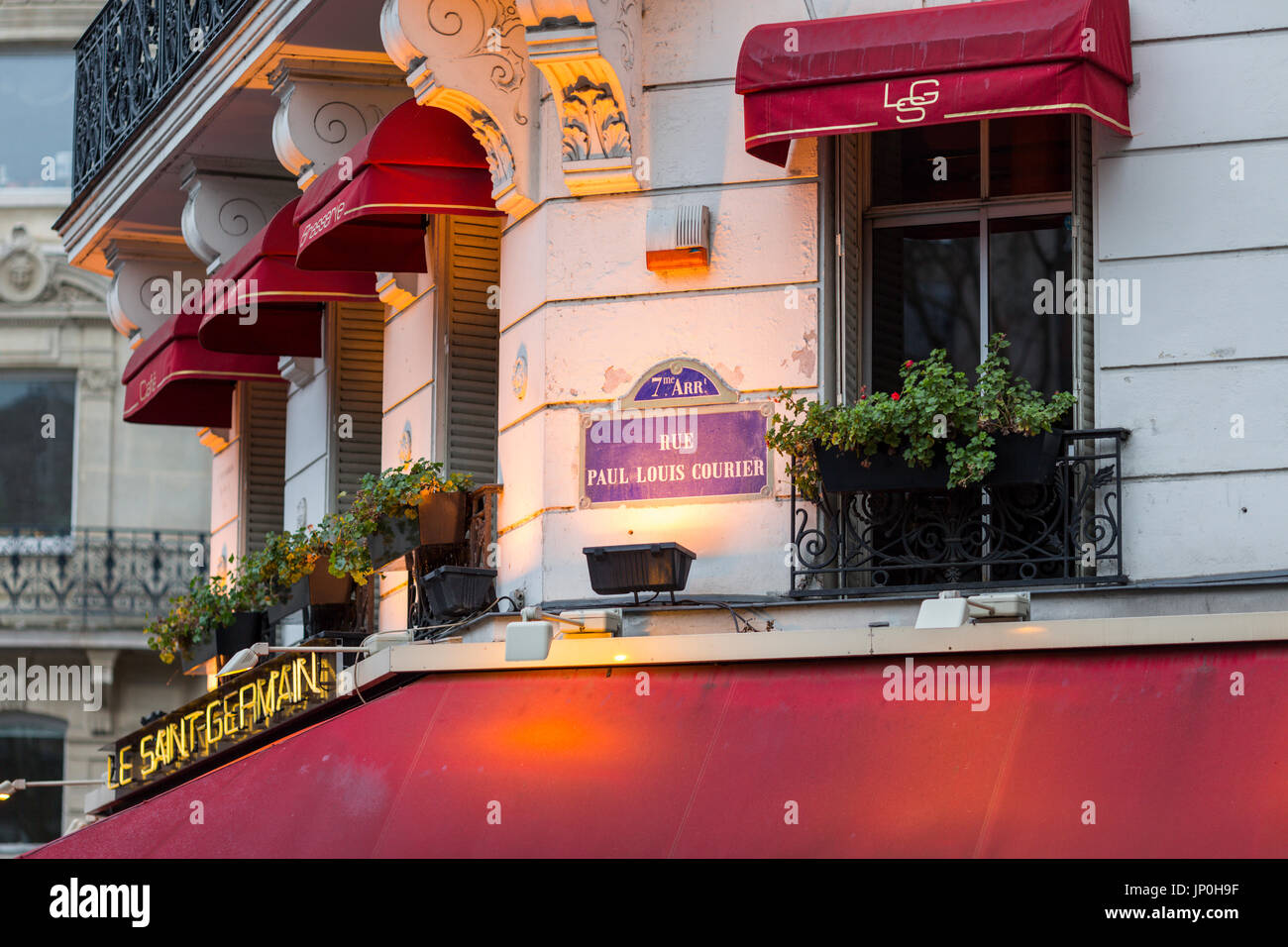 Paris, France - March 2, 2016: Le Saint Germain restaurant cafe with red awnings, early morning with lights still on. Stock Photo