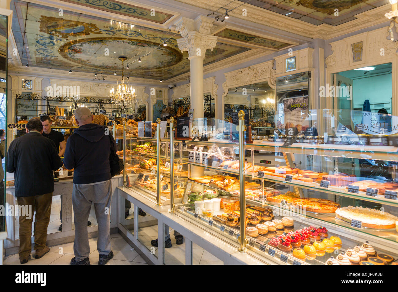 Paris, France - March 2, 2016: Interior of a classic Paris bakery and bread shop with people buying their daily bread. There are many classic boulangeries and patisseries in Paris with beautiful vintage decor. Stock Photo