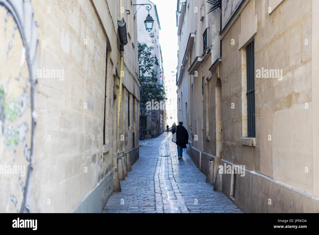 Paris, France - March 2, 2016: Pedestrians in rue du Prevot, a narrow street in the Marais, Paris. Stock Photo