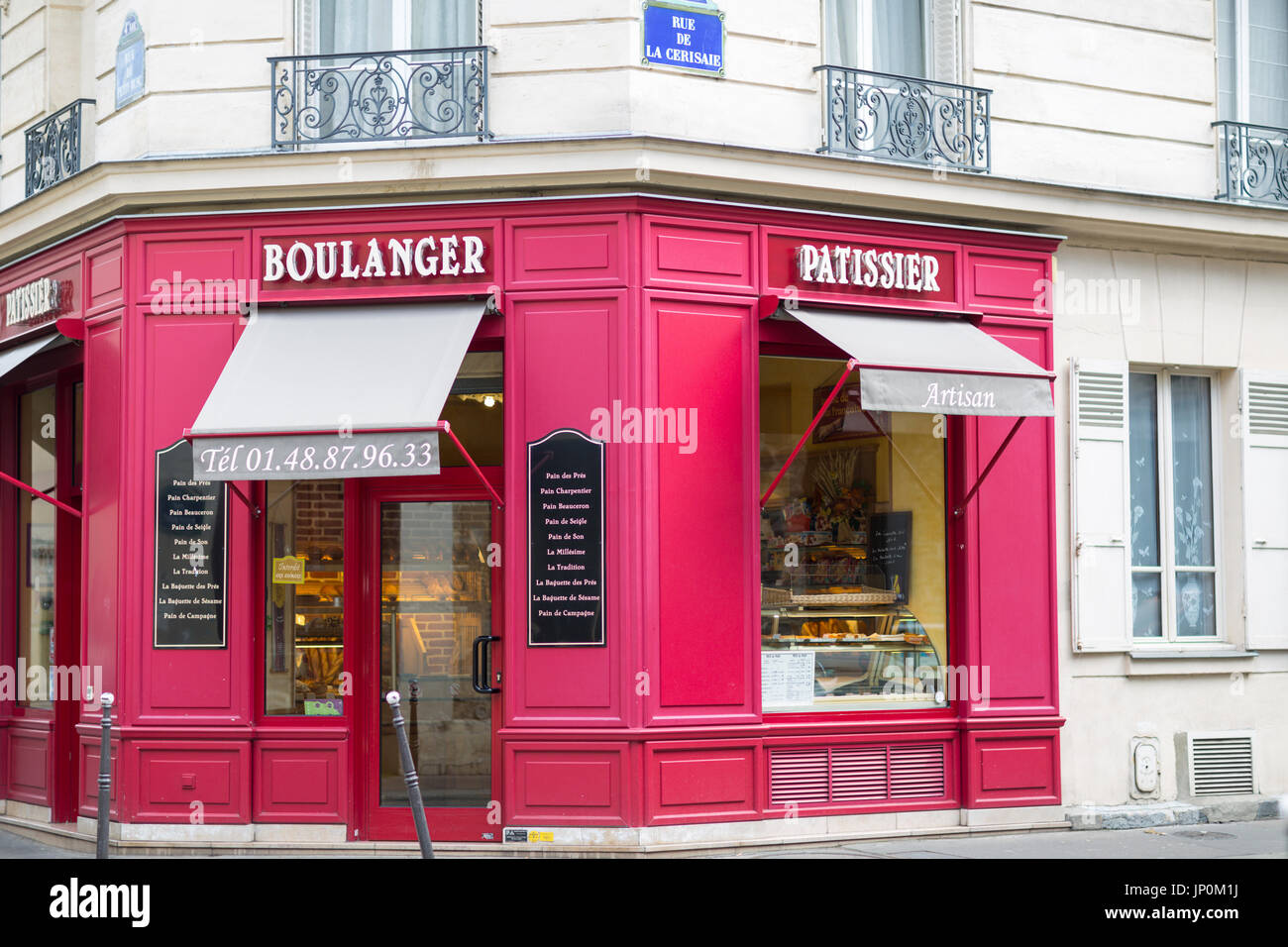 Paris, France - March 2, 2016: Red bakery and pastry shop on the corner of rue du Petit Musc and rue de la Cerisaie in the Marais, Paris. Stock Photo