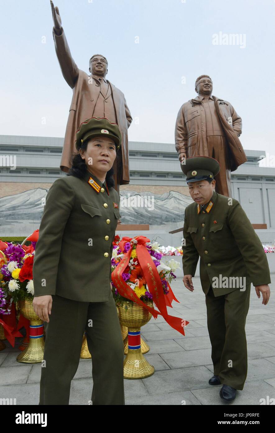 PYONGYANG, North Korea - Soldiers bring flowers to the statues of North