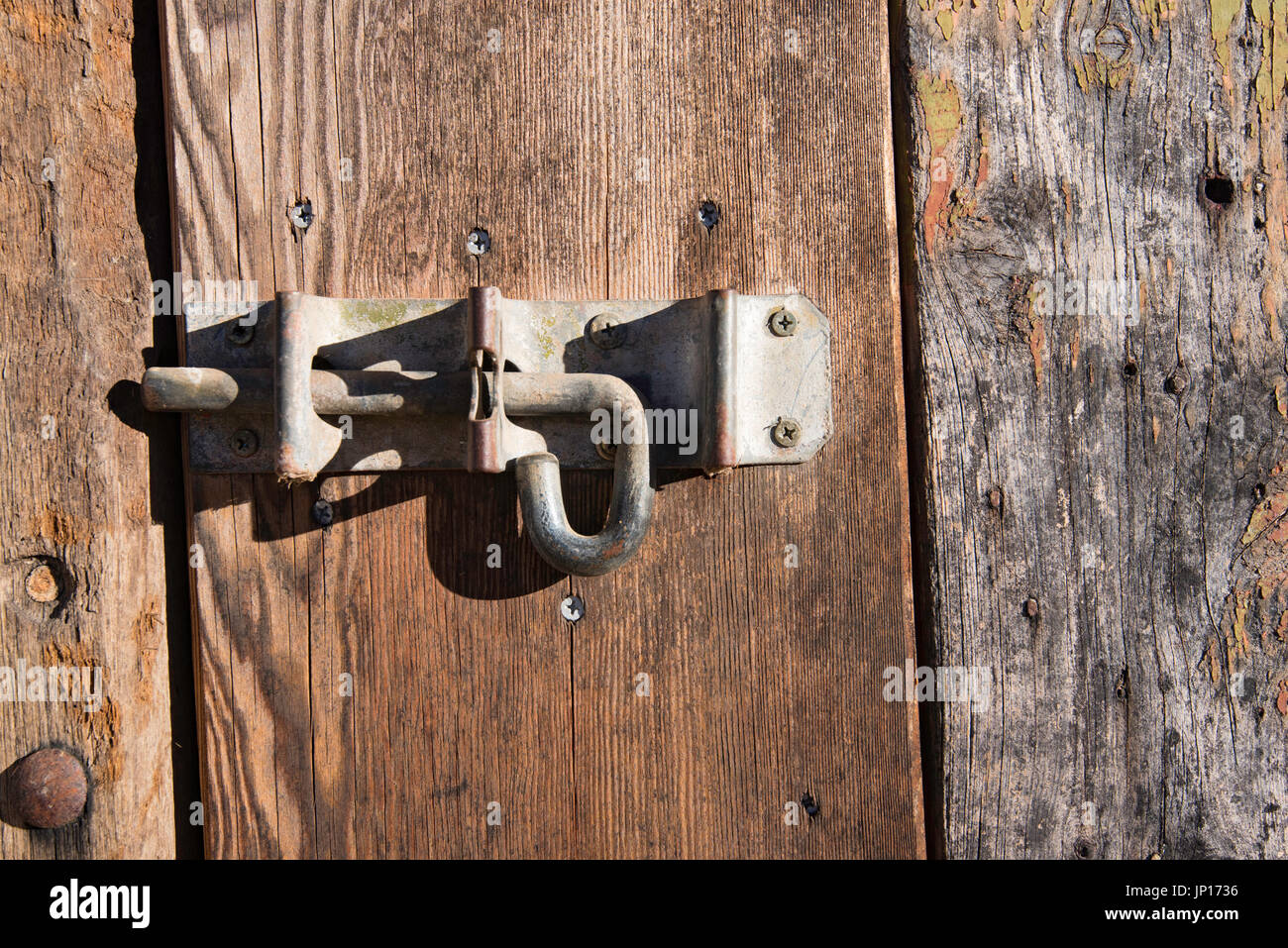 An old slide bolt or pad bolt on a rustic stable door on the historic property Rowlee in Orange, NSW, Australia Stock Photo