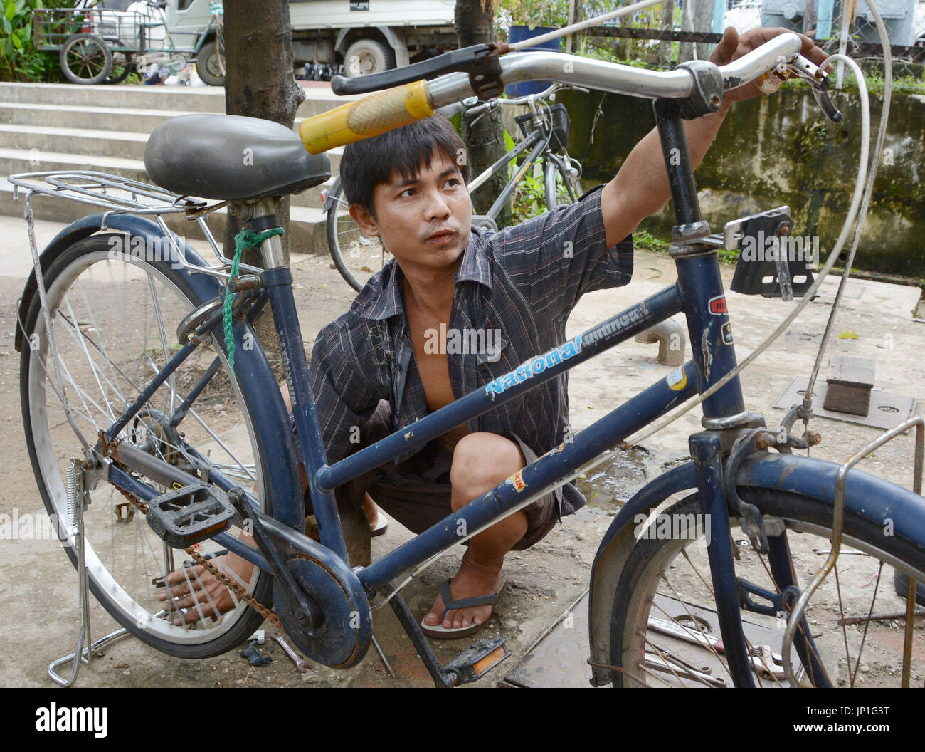 YANGON, Myanmar A man repairs a Japanesemade secondhand bicycle in