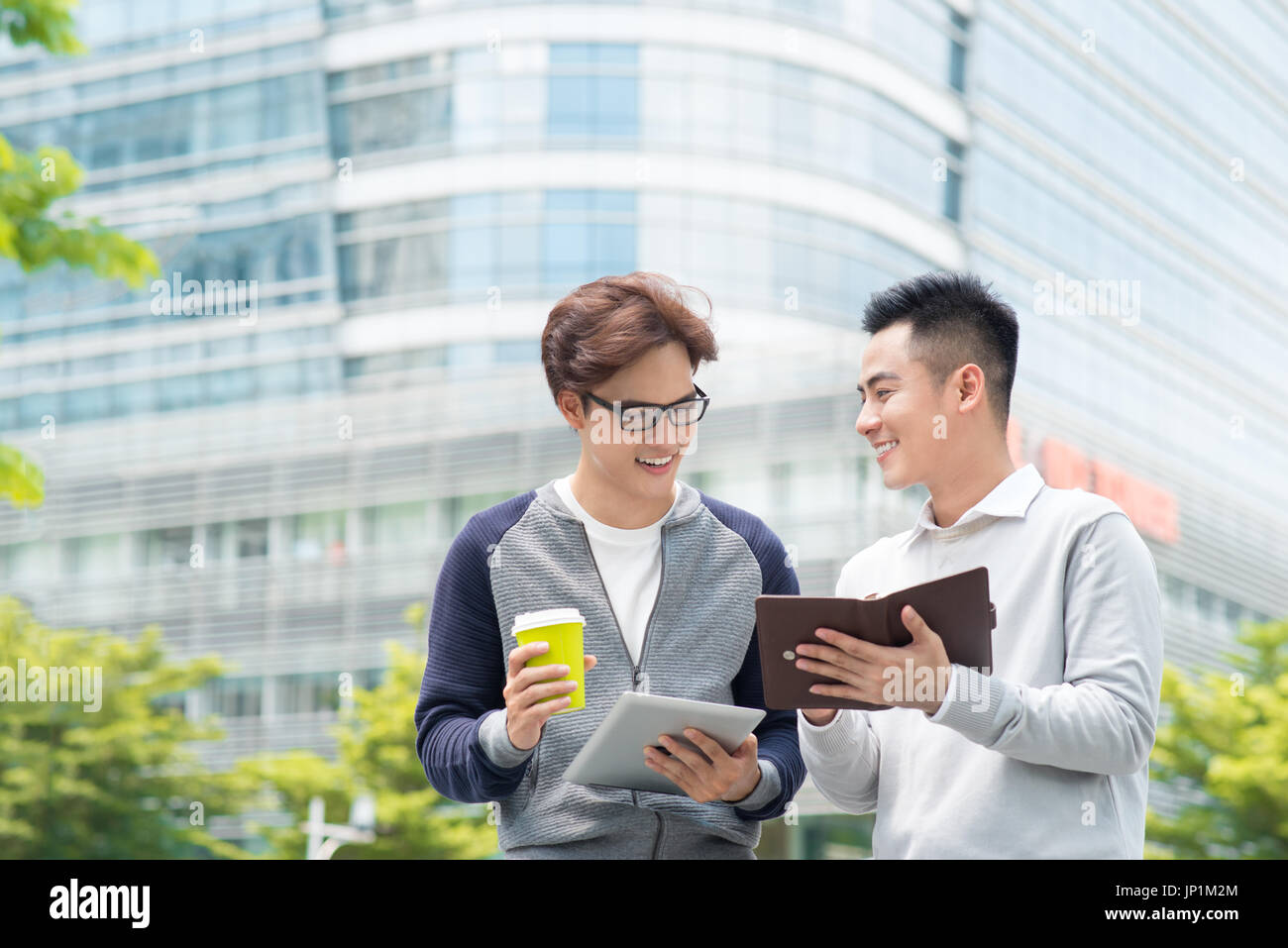 Coffee break. Two cheerful business men talking while one of them holding coffee cup Stock Photo