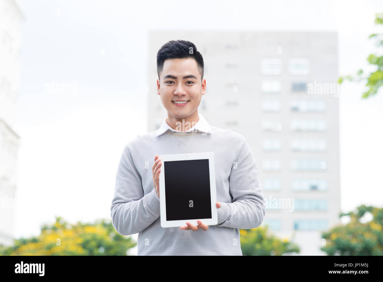 Young Business man holding and showing the screen of tablet Stock Photo ...