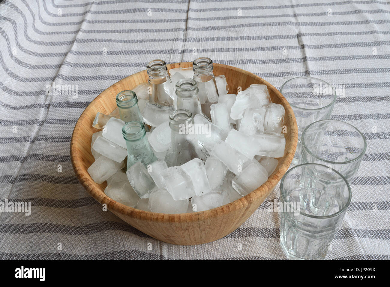 Beverages in bottles on ice in wooden bucket Stock Photo