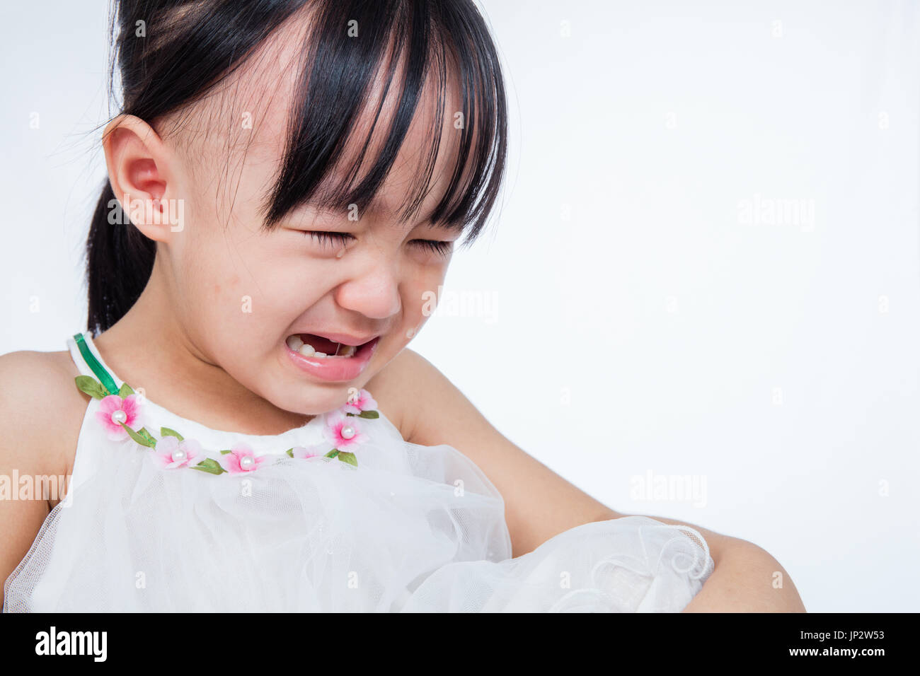 Crying Asian Chinese little girl in isolated white background Stock Photo
