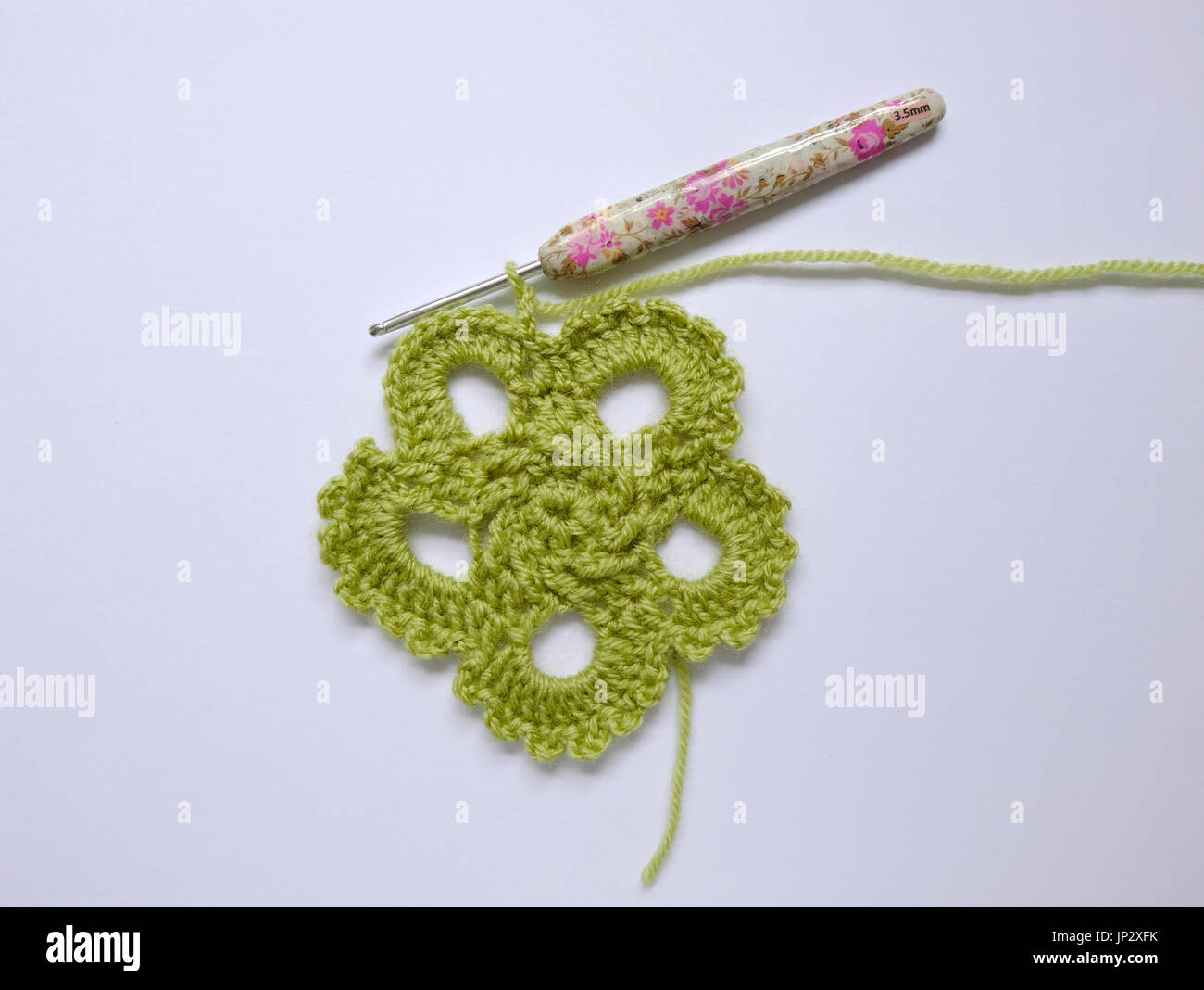 Work in progress on a green crocheted motif Stock Photo