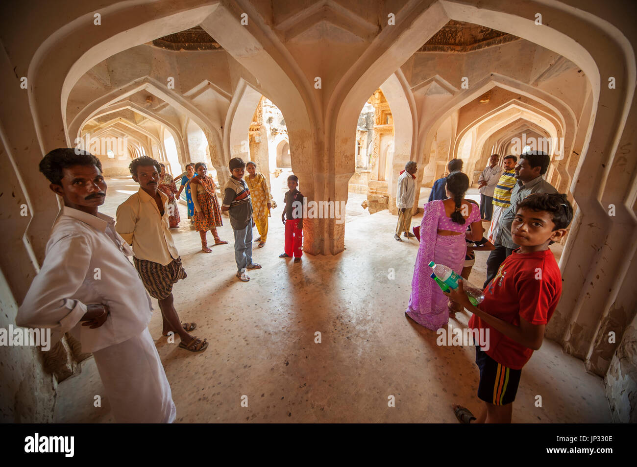 Indian people on the corridor of the Queen's Bath Palace, Hampi, Karnataka, India Stock Photo