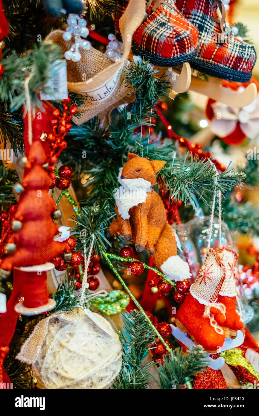 Christmas tree decorations and lights hanging on a traditional Christmas tree during the Christmas holiday season. Stock Photo