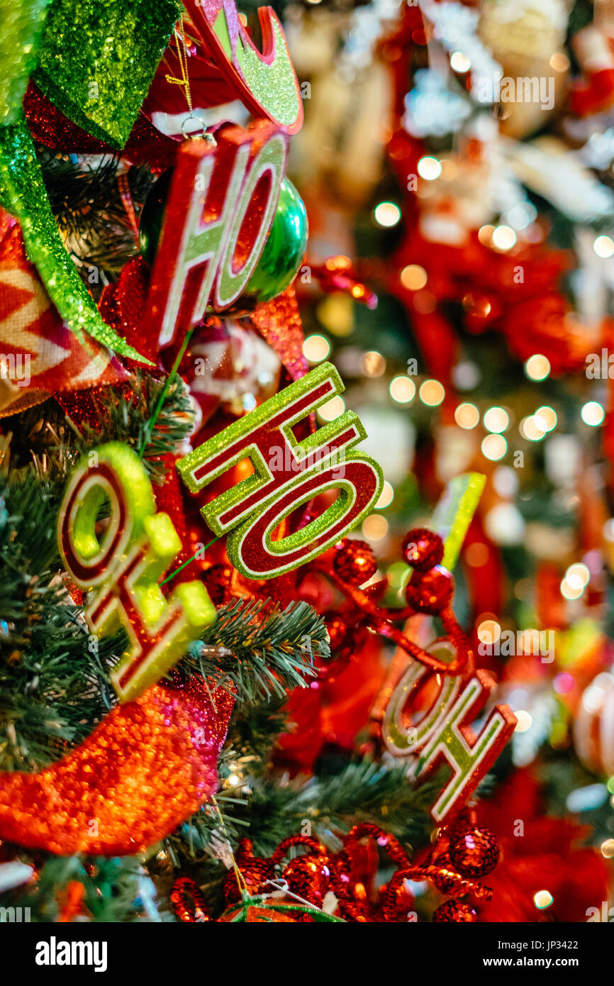 Christmas tree decorations and lights hanging on a traditional Christmas tree during the Christmas holiday season. Stock Photo