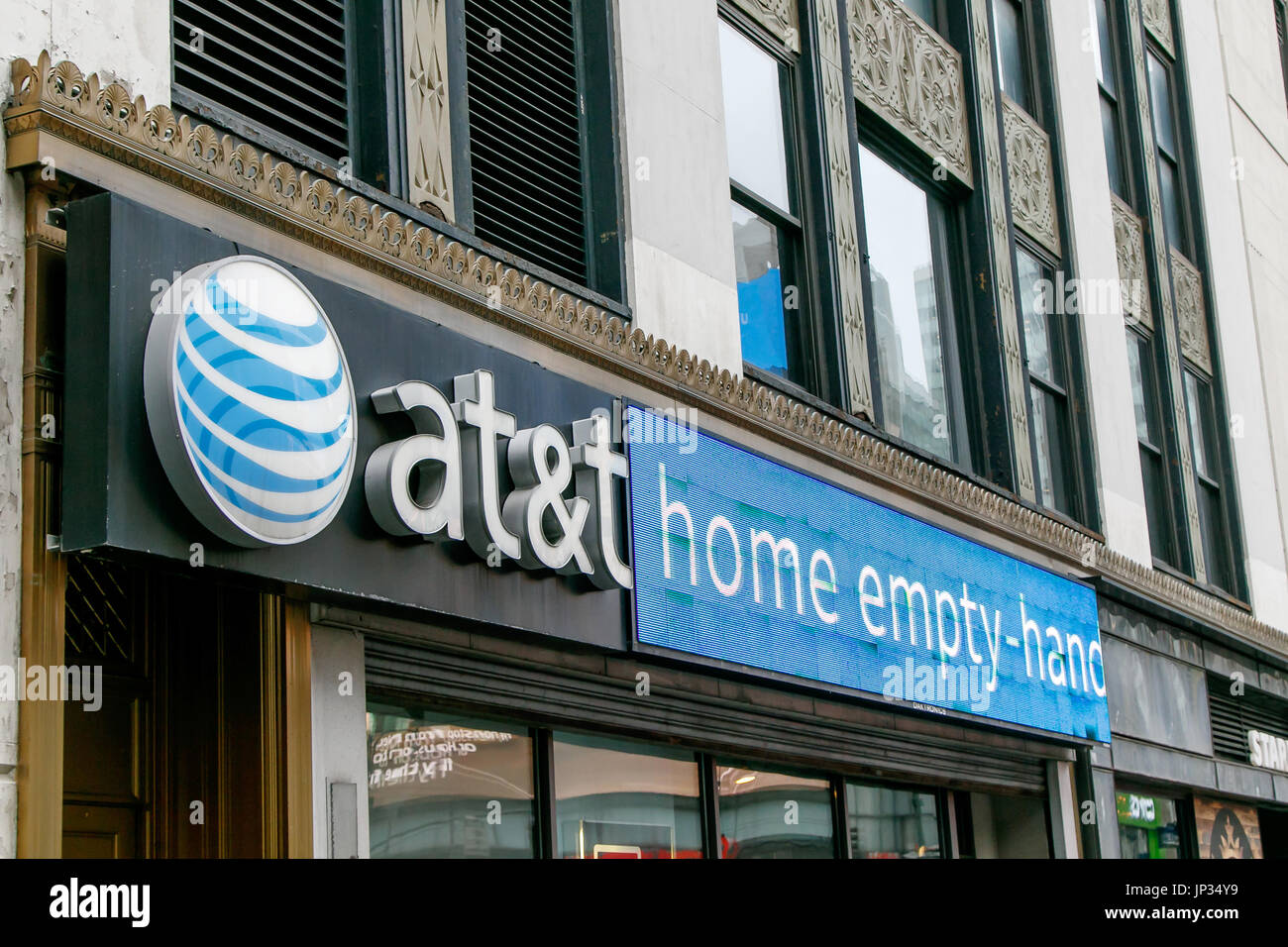 Logo and electronic display above the entrance to an AT&T retail store in Manhattan. Stock Photo
