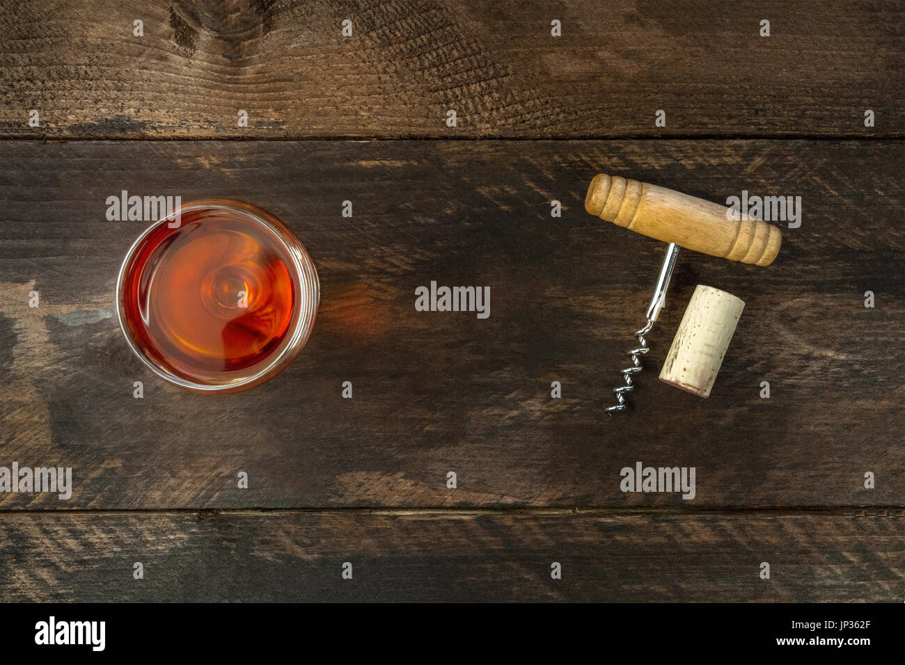 Photo of old-fashioned corkscrew with cork, shot from above on dark