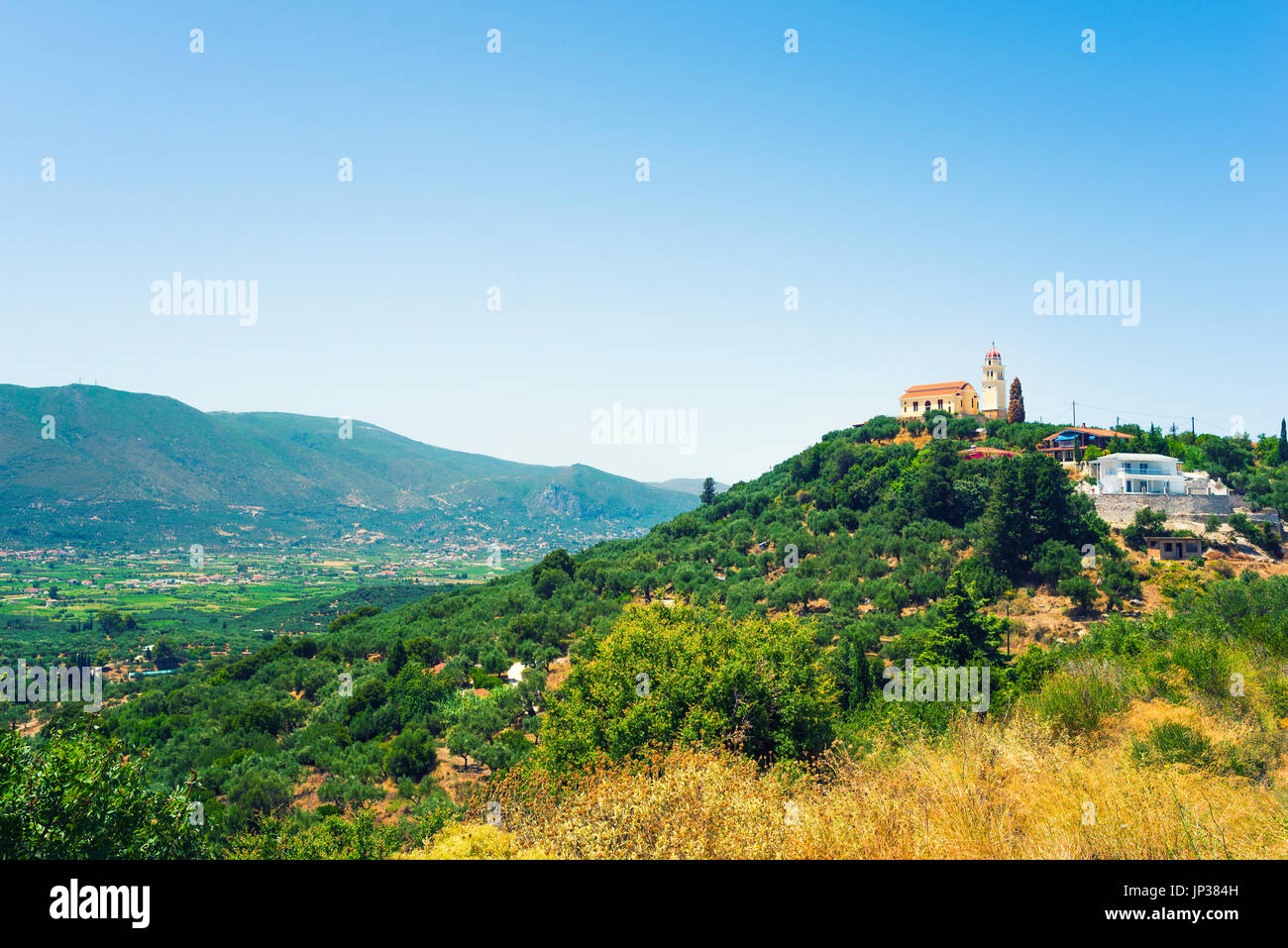 Green fields and mountainous village. Summer sunny day in mountains. Mountain landscape Stock Photo