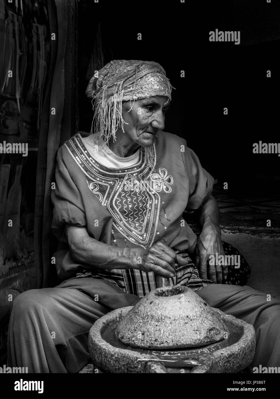 Elderly Moroccan lady making 'Amlou' in Essaouira. Amlou is a Moroccan recipe from the region of Agadir. It is a small marvel of simplicity and taste. Stock Photo