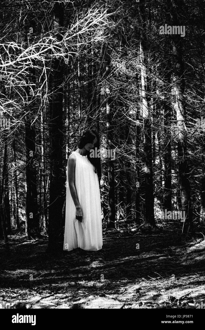 Ghost covered with a white ghost sheet on a rural path. Grainy textured image Stock Photo