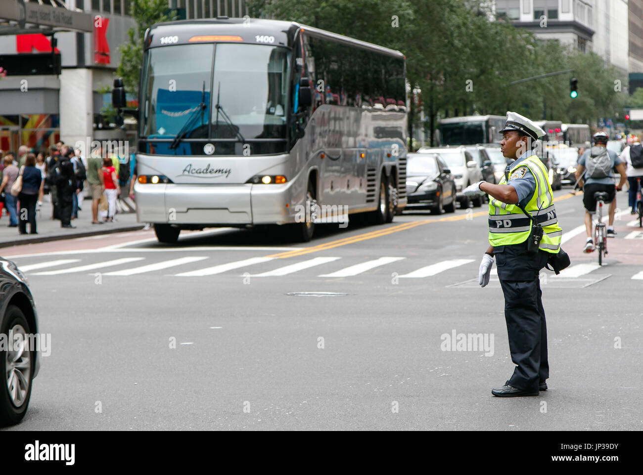 African American police woman is directing traffic during the day in Manhattan. Stock Photo